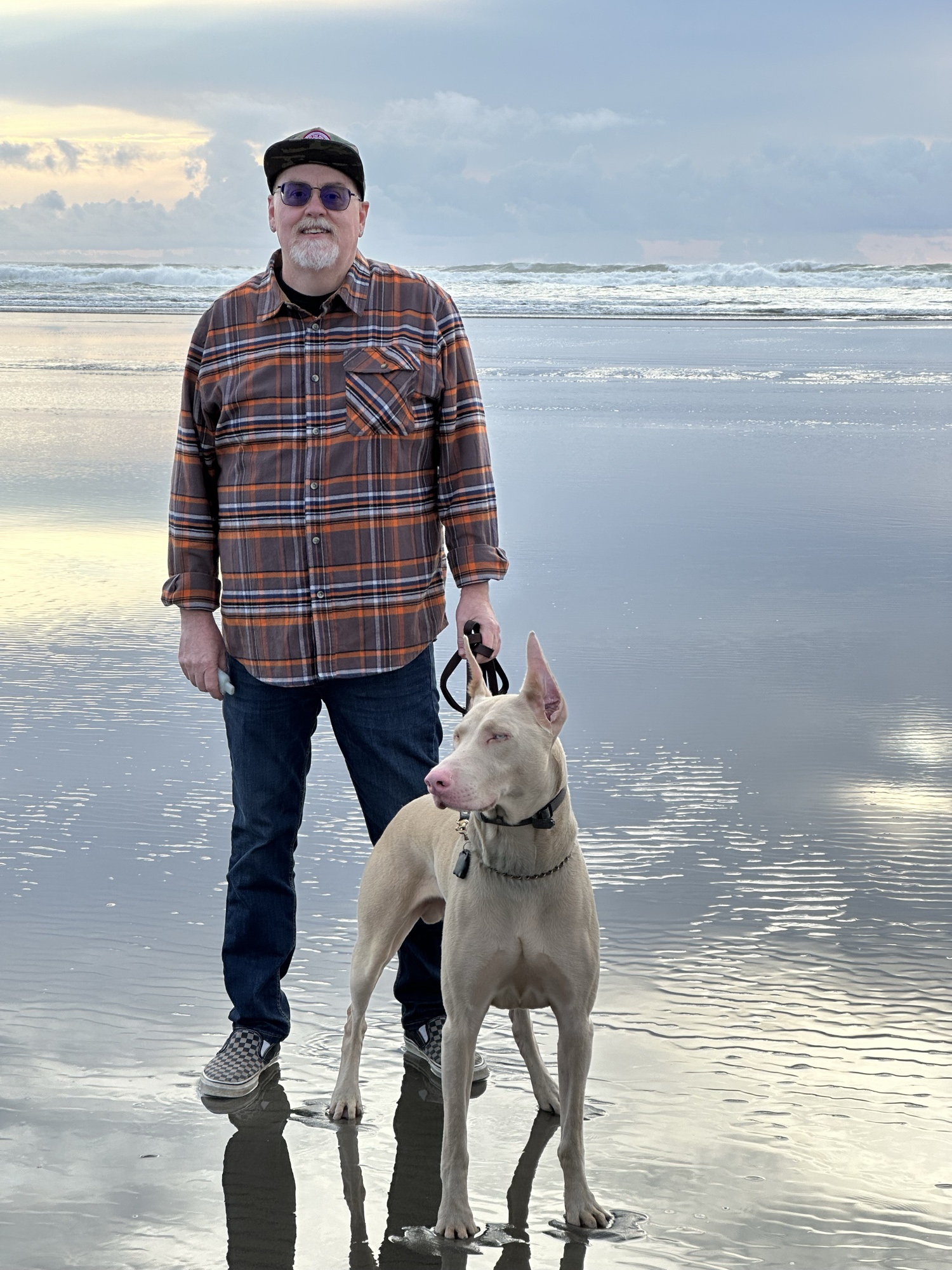 David walking with Oyuki on wet sand at golden hour